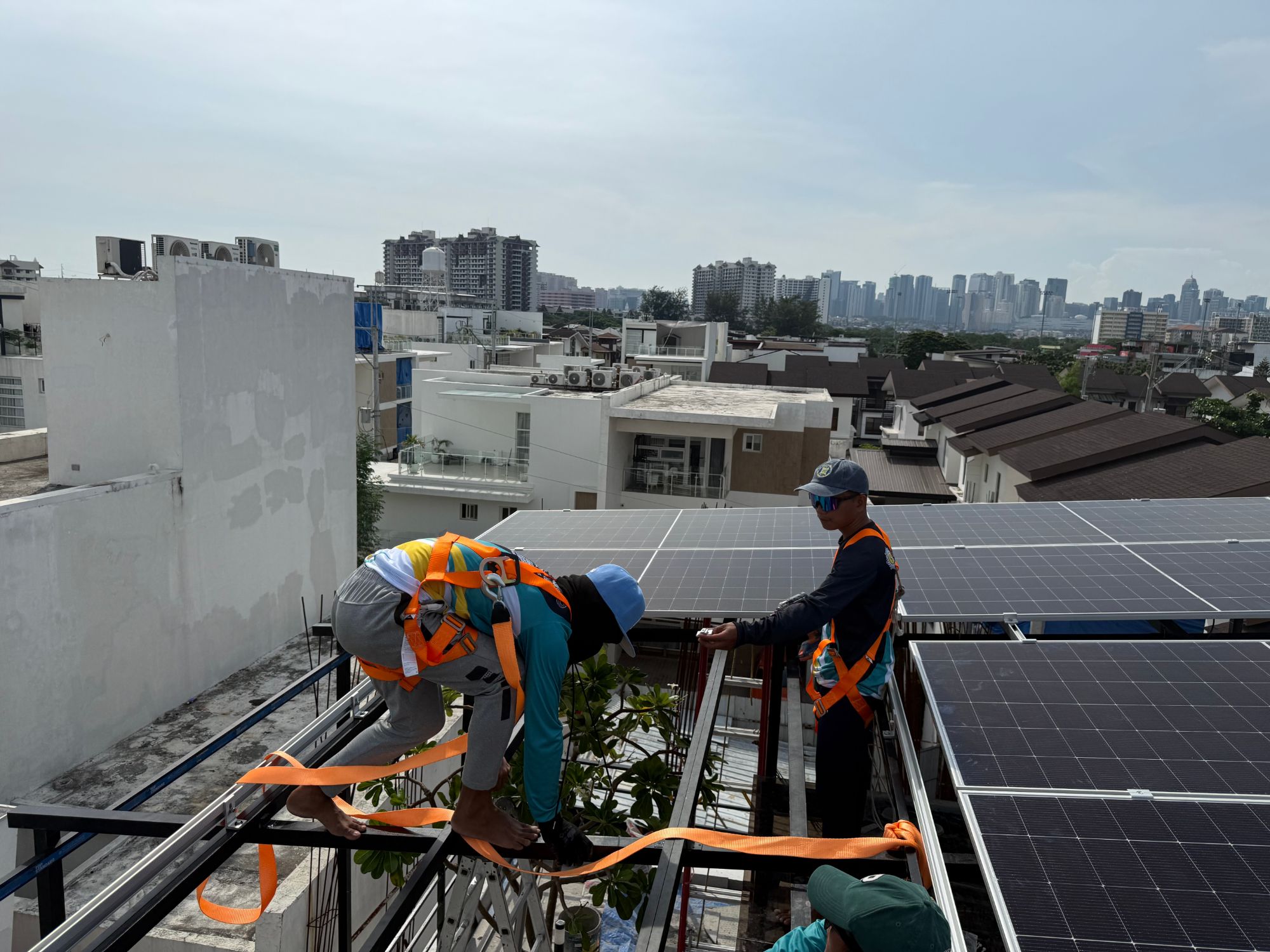 Solar panel installation on a rooftop with the Metro Manila skyline in the background