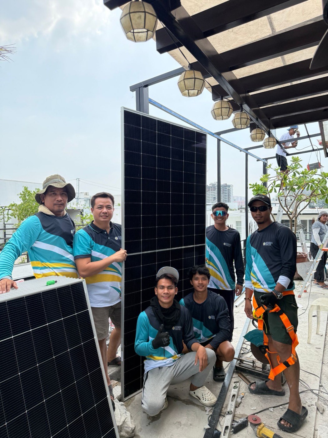 Bolinao Solar installation team with a solar panel on a rooftop